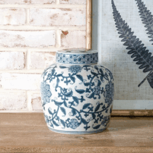 Blue and white porcelain vase with floral patterns on a wooden surface.